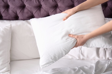 Photo of Young woman making bed, closeup