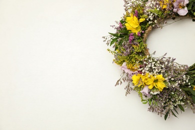 Photo of Wreath made of beautiful flowers on white background, top view. Space for text