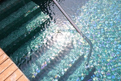 Outdoor swimming pool with steps and rail at resort