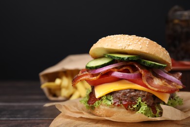 Photo of Tasty burger with bacon, vegetables and patty on wooden table, closeup. Space for text