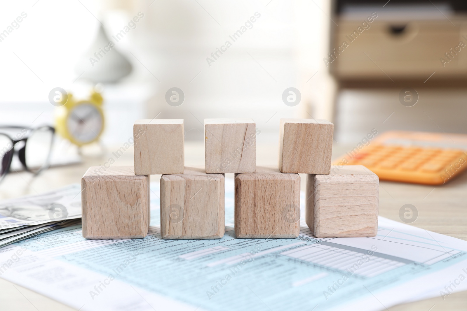 Photo of Taxes. Wooden cubes and documents on table, closeup