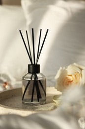 Photo of Aromatic reed air freshener and flower on bed