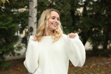 Photo of Happy woman in stylish warm sweater outdoors