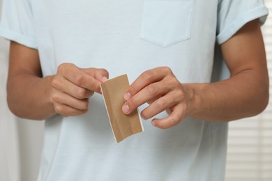 Photo of Man with sticking plaster indoors, closeup view