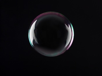 Photo of Beautiful translucent soap bubble on dark background. Space for text