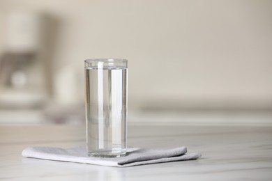 Photo of Glass of pure water on white table indoors, space for text