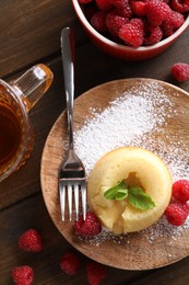 Tasty vanilla fondant with white chocolate and raspberries served on wooden table, flat lay