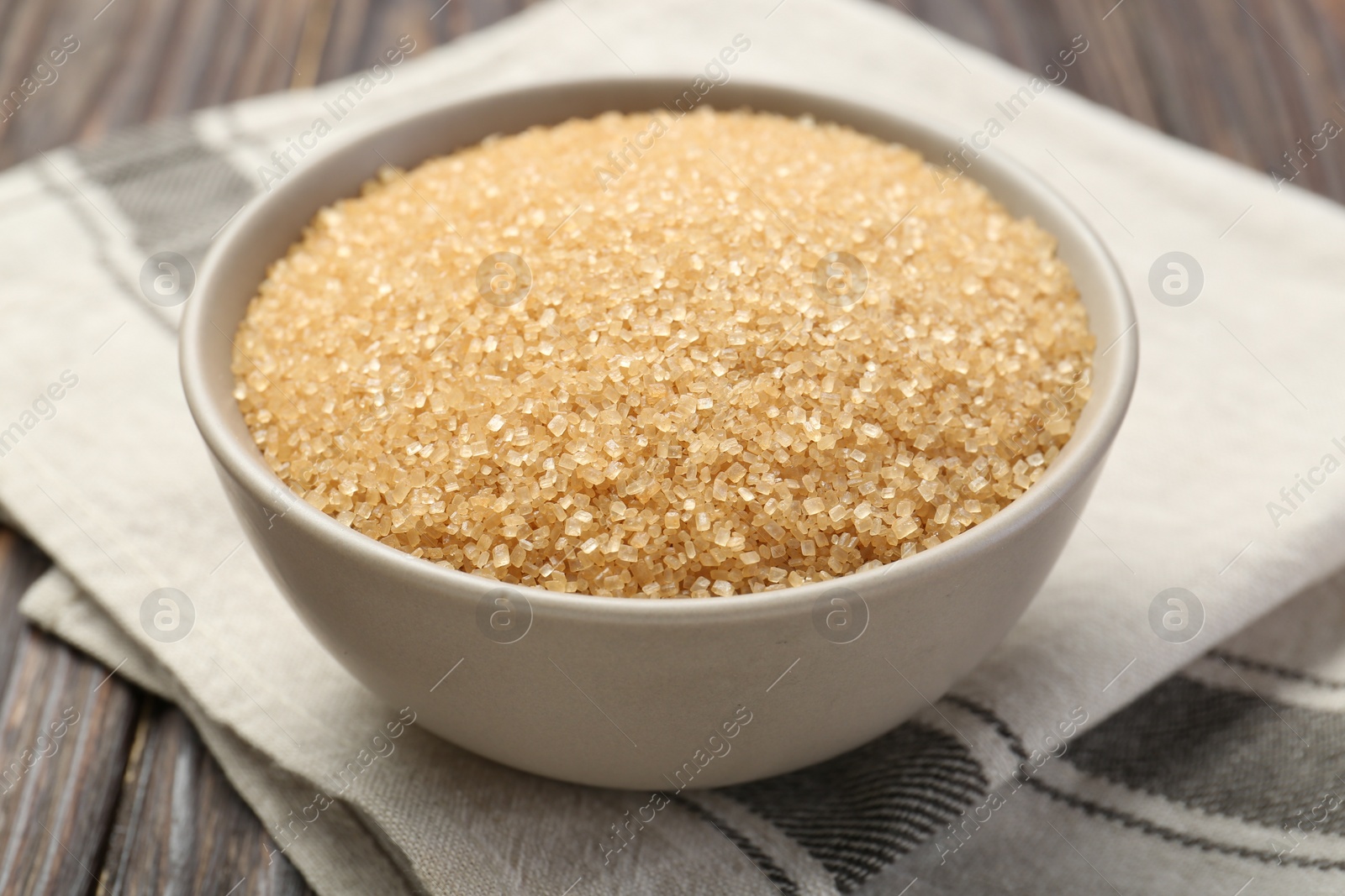 Photo of Brown sugar in bowl on table, closeup