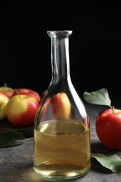 Photo of Natural apple vinegar and fresh fruits on grey table