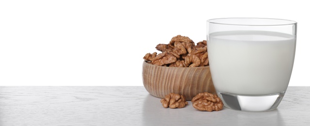 Photo of Glass of walnut milk on table against white background