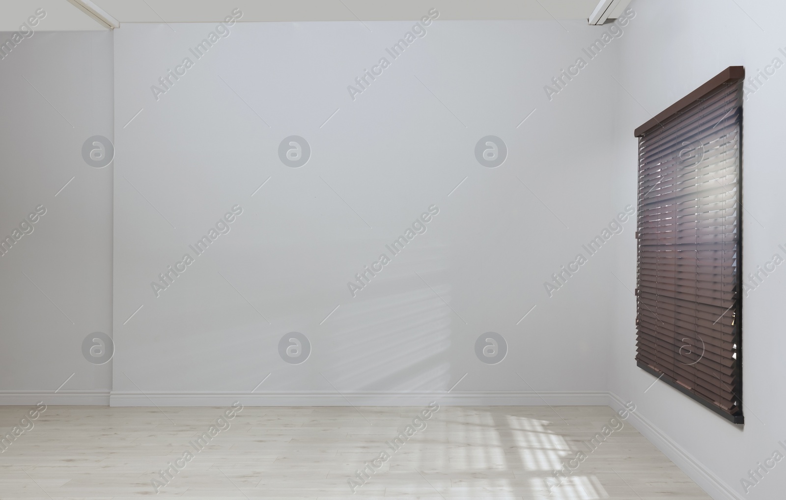 Photo of Empty room with white walls, large window and wooden floor