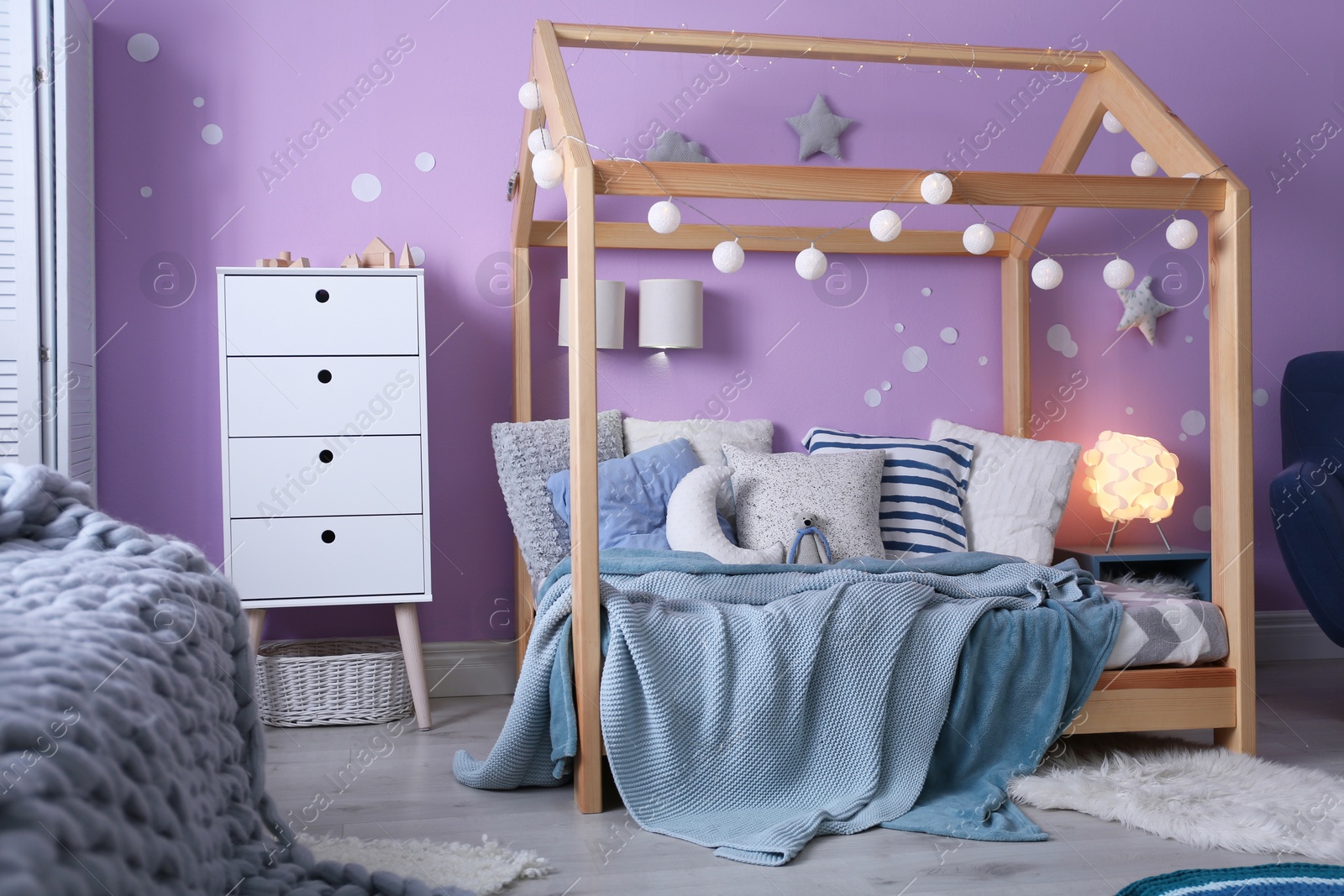 Photo of Child's room interior with comfortable bed and garland