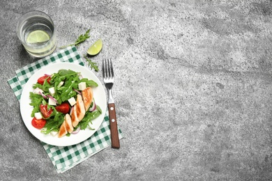 Photo of Delicious salad with meat, arugula and vegetables on grey table, flat lay. Space for text