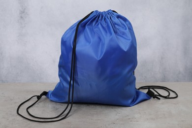 Blue drawstring bag on grey textured table