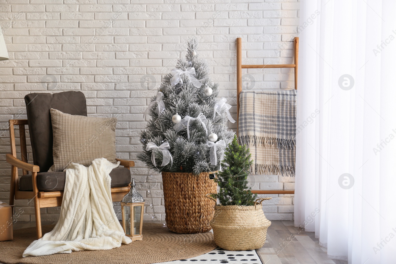 Photo of Stylish interior with beautiful Christmas tree near white brick wall