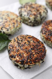 Photo of Delicious vegan cutlets with sesame on white table, closeup