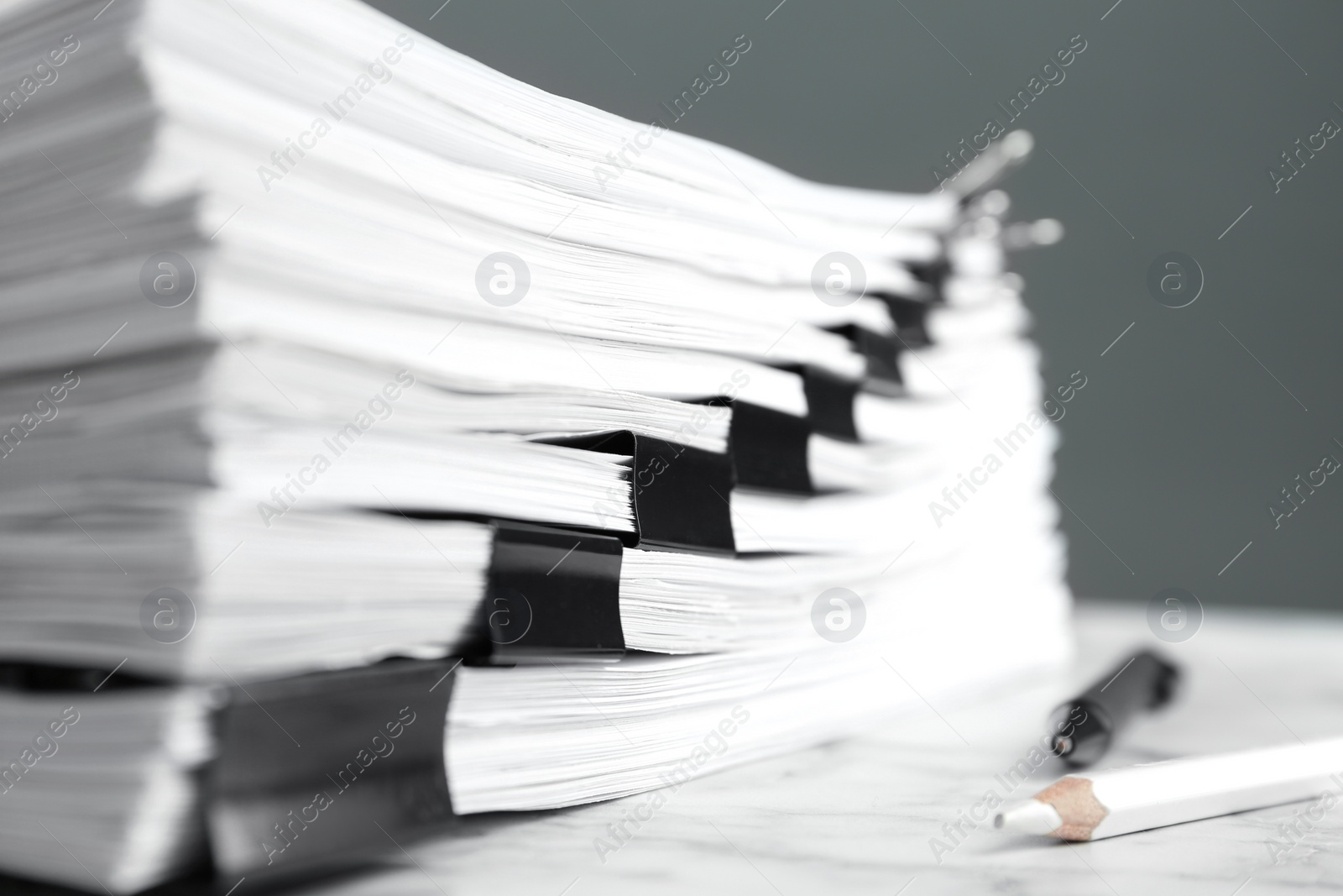 Photo of Stack of documents with binder clips on marble table, closeup