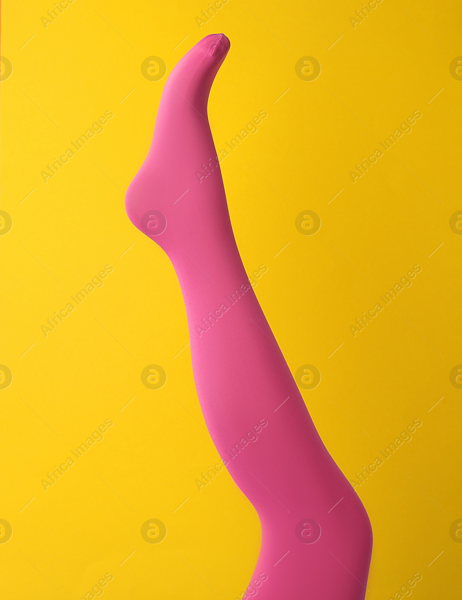 Photo of Leg mannequin in pink tights on yellow background