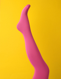 Photo of Leg mannequin in pink tights on yellow background