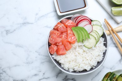 Photo of Delicious poke bowl with salmon and vegetables served on white marble table, flat lay. Space for text