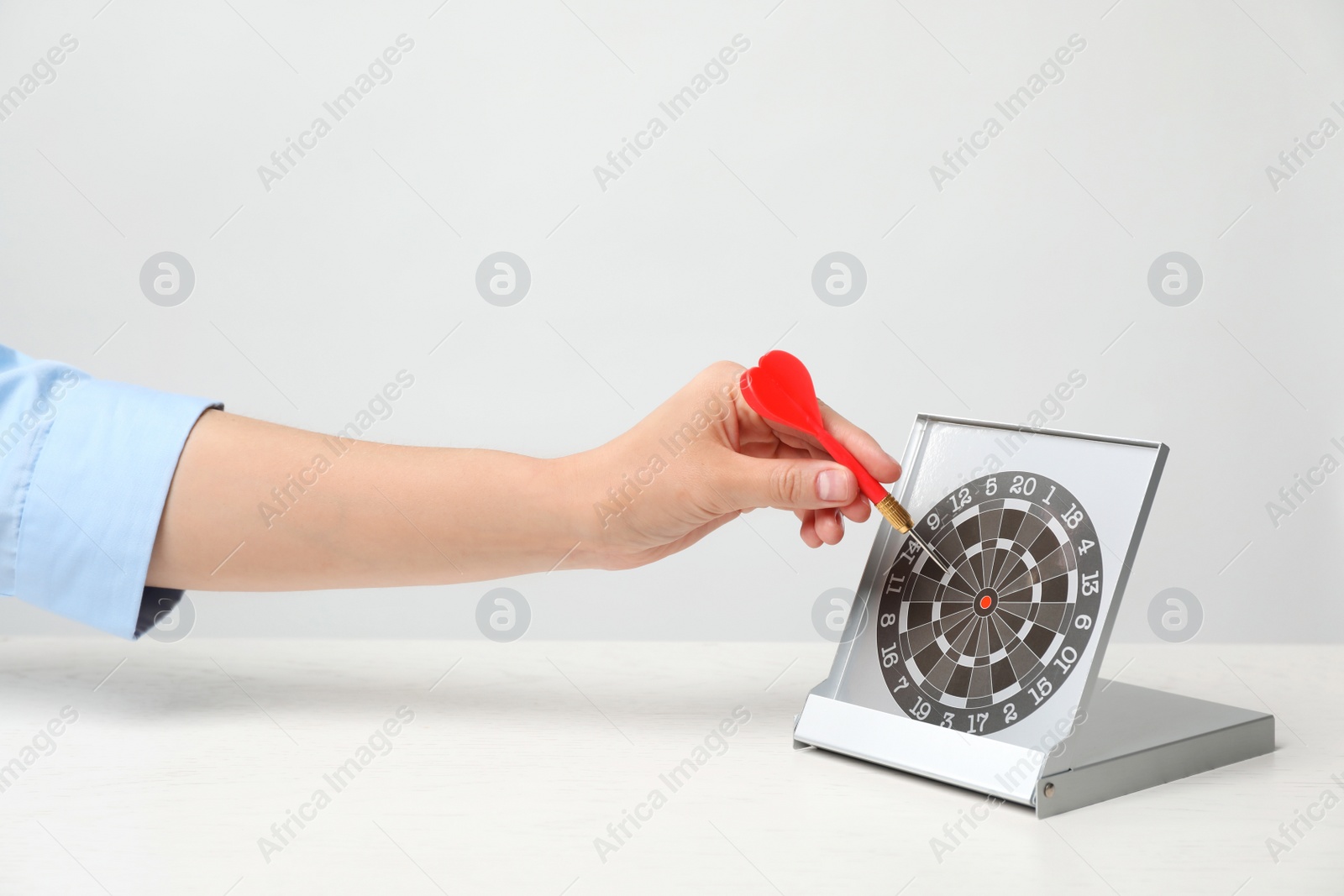 Photo of Woman with darts at table. Business trainer concept