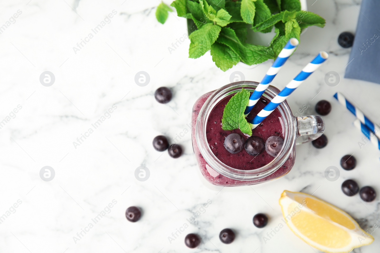 Photo of Mason jar with delicious acai smoothie on table, top view