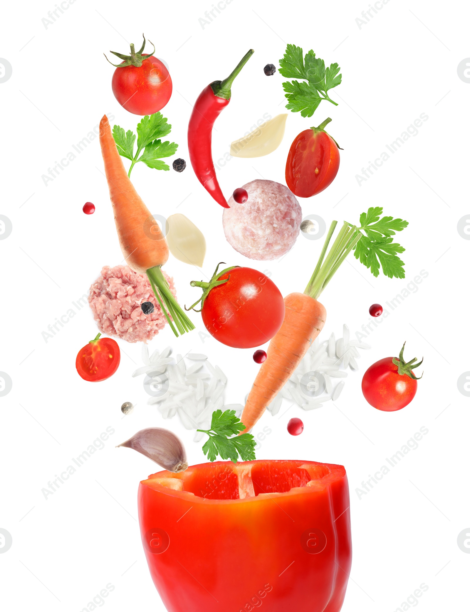 Image of Stuffed pepper recipe. Fresh ingredients falling into bell pepper on white background