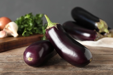 Photo of Ripe purple eggplants on wooden table, closeup