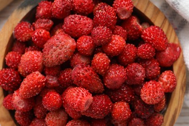 Fresh wild strawberries in bowl on table, top view