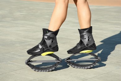 Woman in kangoo jumping boots outdoors on sunny day, closeup