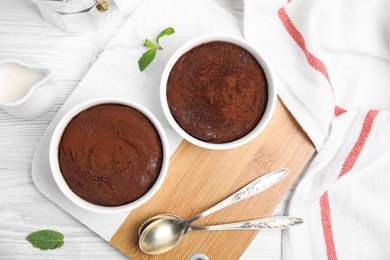 Photo of Delicious chocolate fondant on white wooden table, flat lay