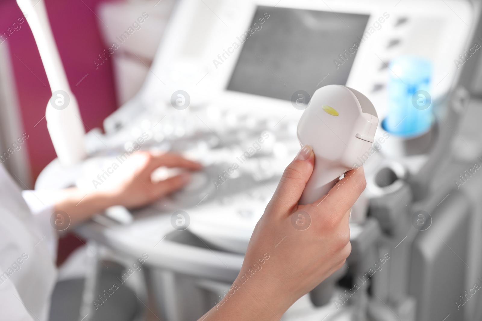 Photo of Sonographer holding ultrasound machine probe in clinic, closeup