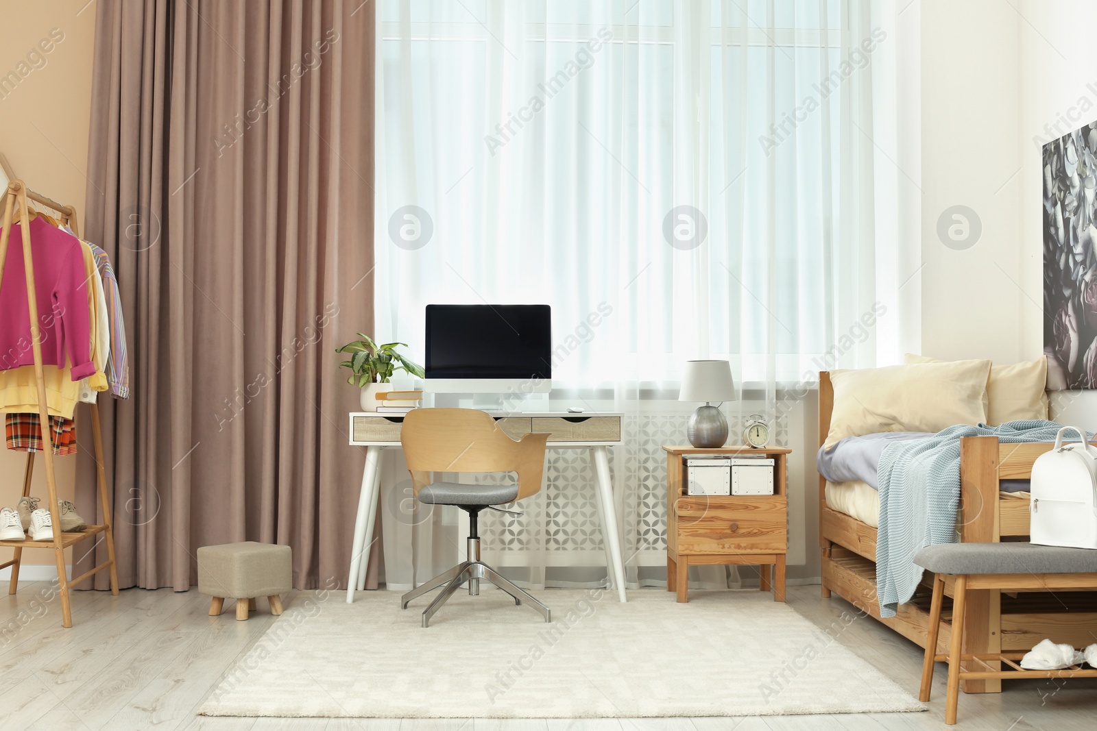 Photo of Stylish teenager's room interior with computer and comfortable bed