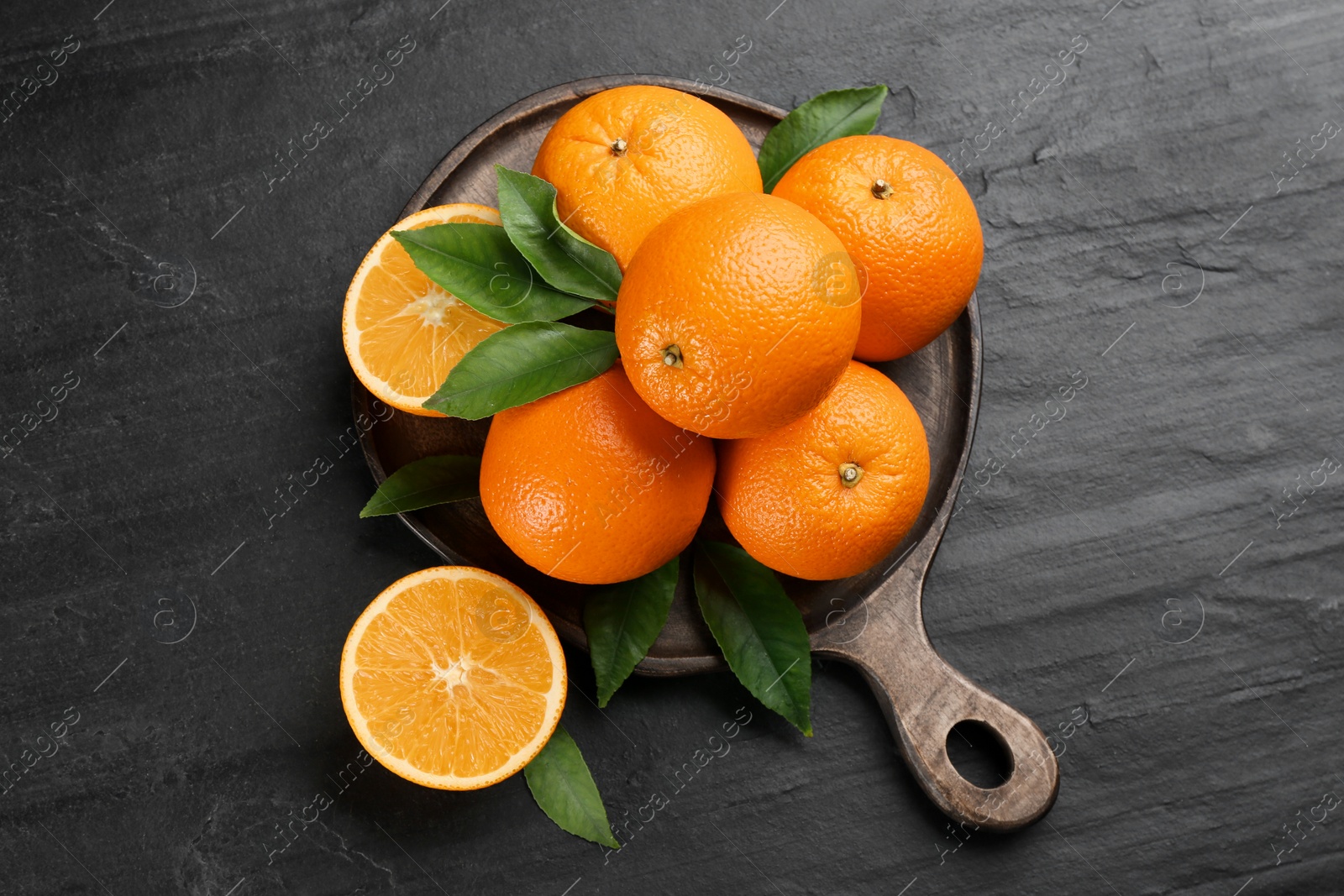 Photo of Delicious ripe oranges on black table, flat lay