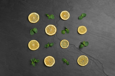Photo of Lemonade layout with juicy lemon slices and mint on black table, top view