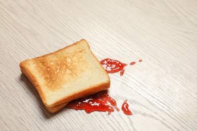 Photo of Overturned toast bread with jam on floor