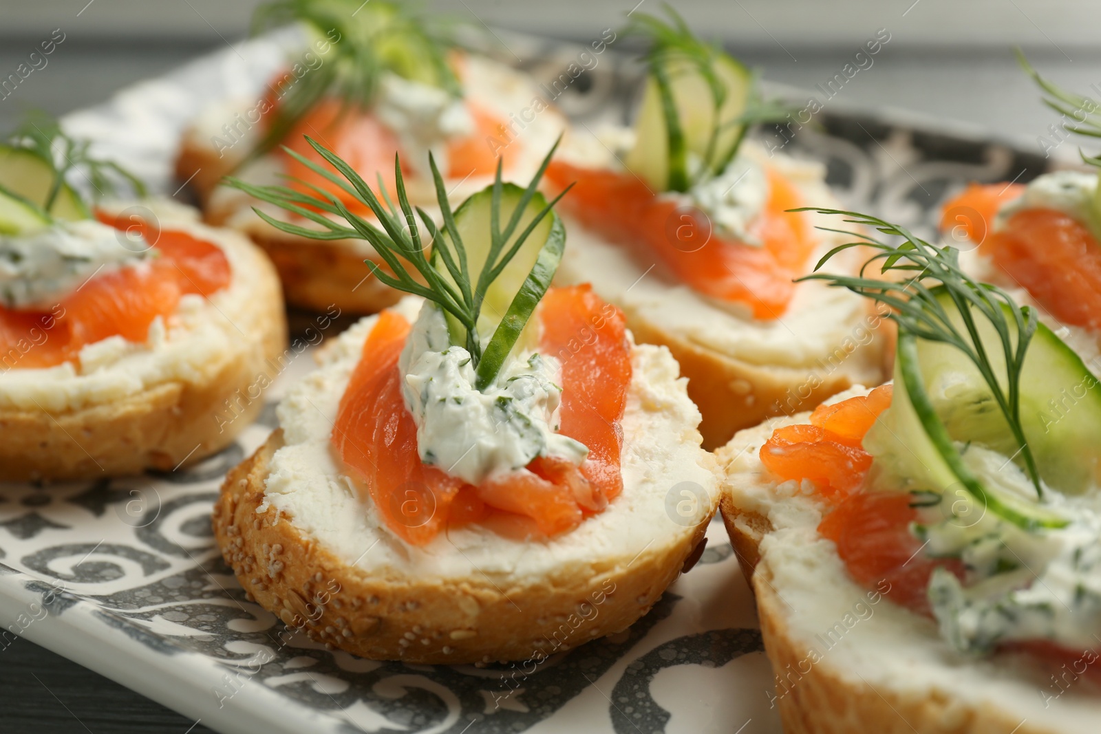 Photo of Tasty canapes with salmon, cucumber, cream cheese and dill on table, closeup