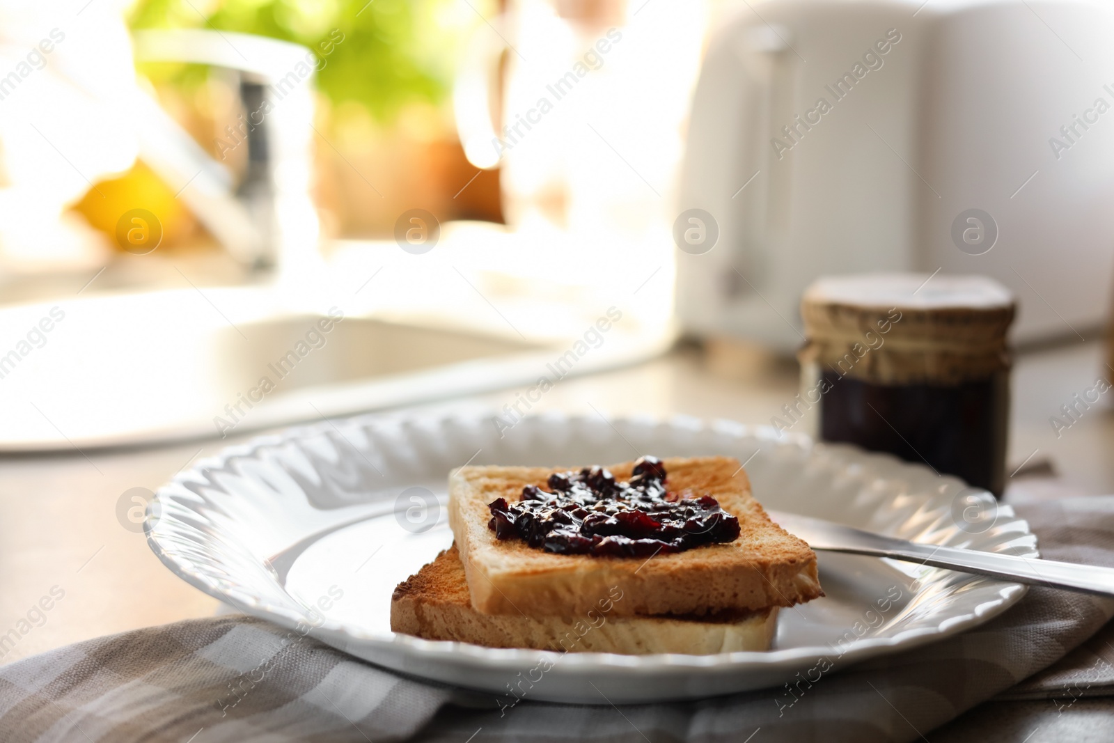 Photo of Tasty toasts with jam on countertop in kitchen, closeup