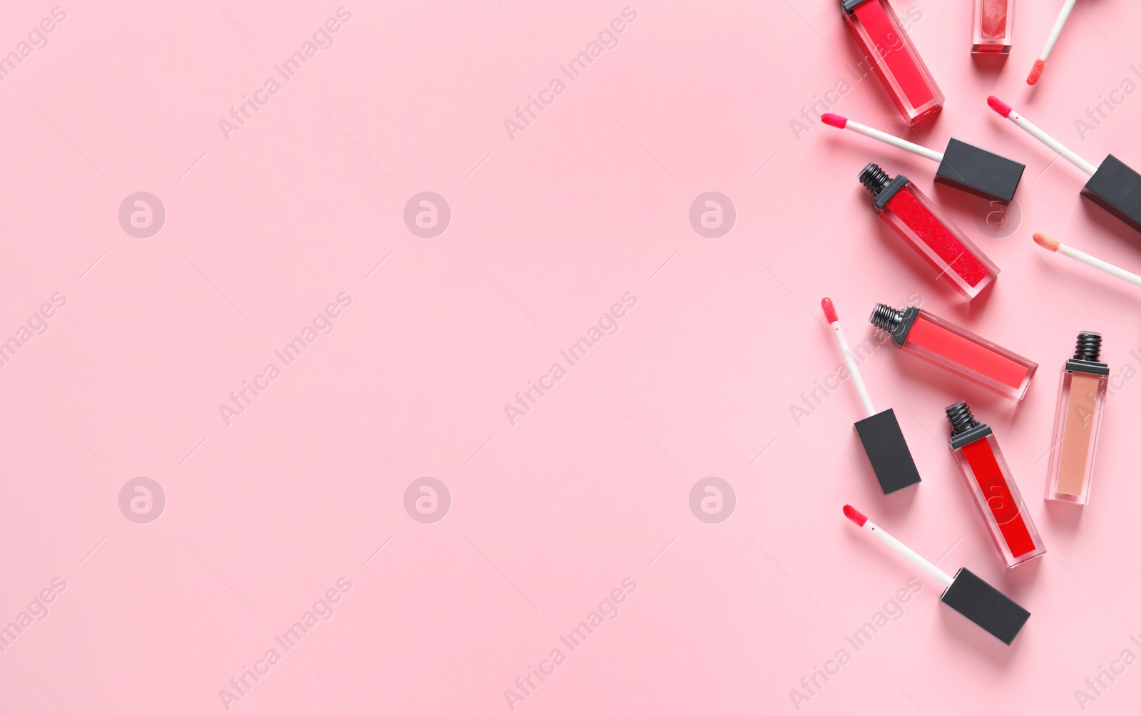 Photo of Beautiful flat lay composition of liquid lipsticks and space for text on color background