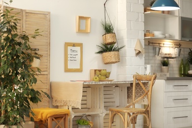 Photo of Modern kitchen interior with wooden crates as eco furniture