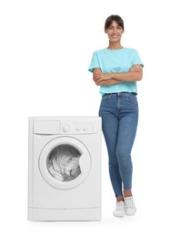 Beautiful woman near washing machine with laundry on white background