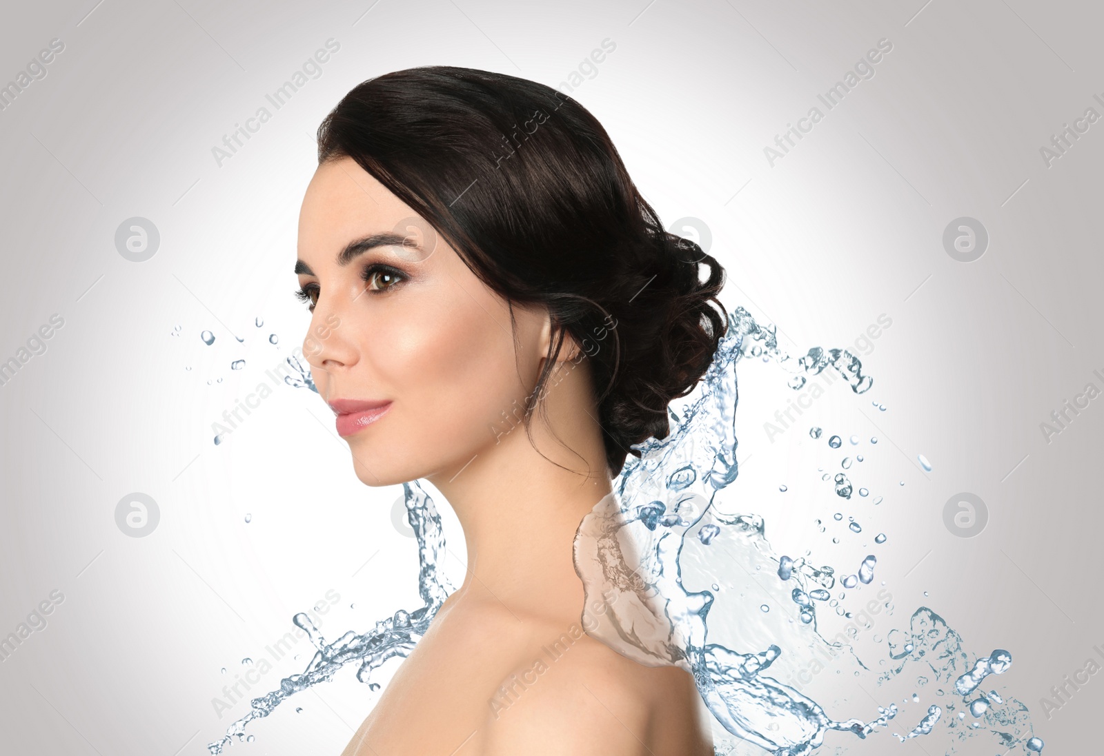 Image of Beautiful young woman and splashing water on light background. Spa portrait