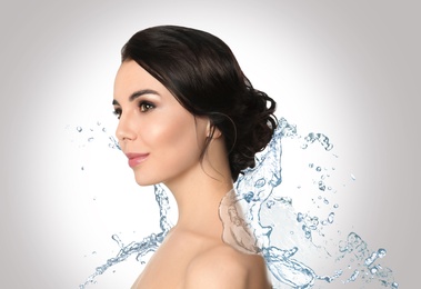 Image of Beautiful young woman and splashing water on light background. Spa portrait