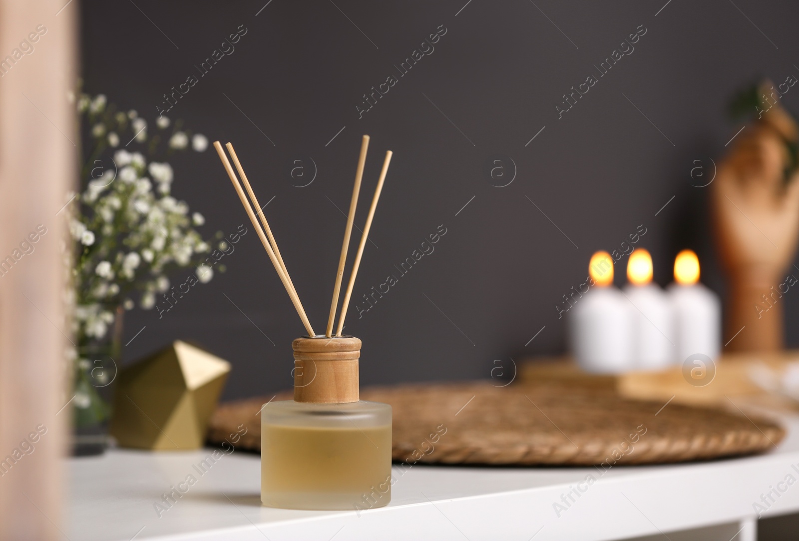 Photo of Reed diffuser on white table in modern bathroom