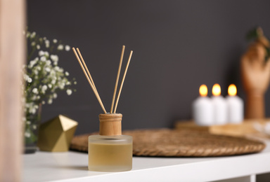 Photo of Reed diffuser on white table in modern bathroom