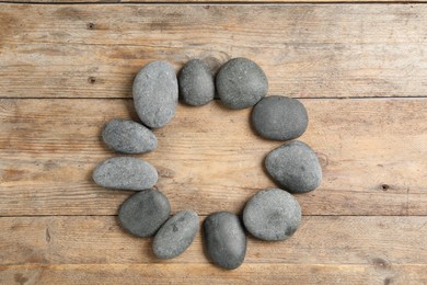 Photo of Frame made with spa stone on wooden table, top view. Space for text