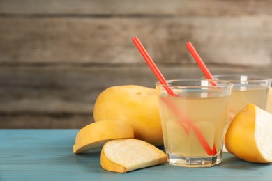 Photo of Glasses of freshly made turnip juice on turquoise wooden table. Space for text