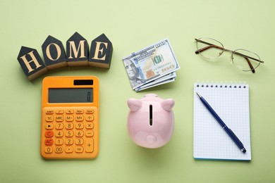 Photo of Flat lay composition with piggy bank and calculator on green background. Paying bills concept