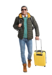 Photo of Man with suitcase walking on white background. Winter travel