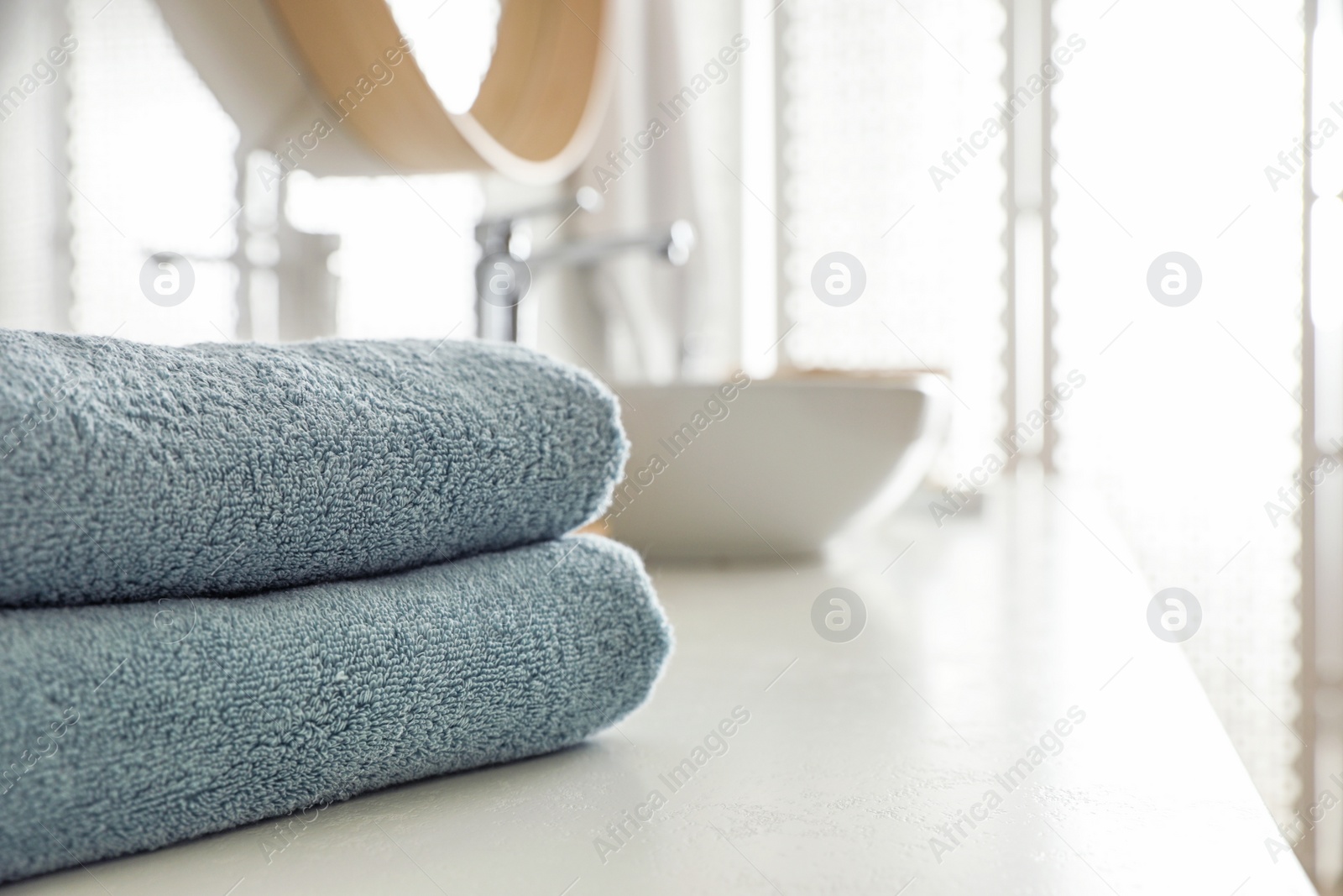 Photo of Stack of clean towels on countertop in bathroom. Space for text